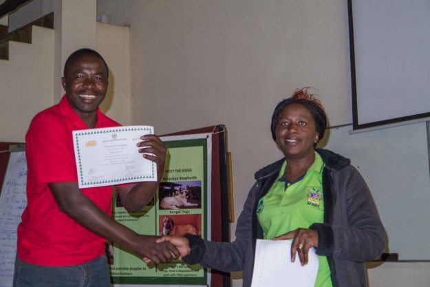 Okamatapati Conservancy chairperson Ebenhard Karita receives his certificate from Chief Forester Helena Lutombi